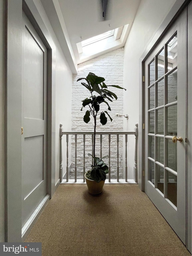 hall with a skylight and carpet flooring