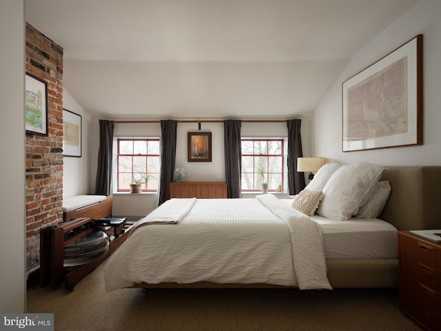 bedroom featuring multiple windows and lofted ceiling