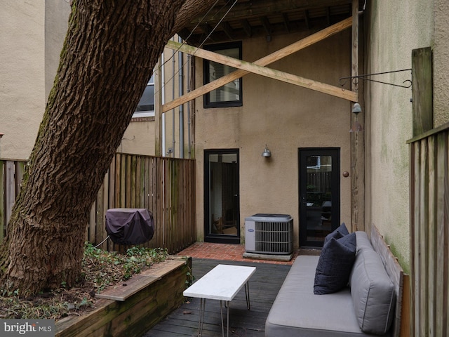 wooden terrace featuring an outdoor living space and central AC unit