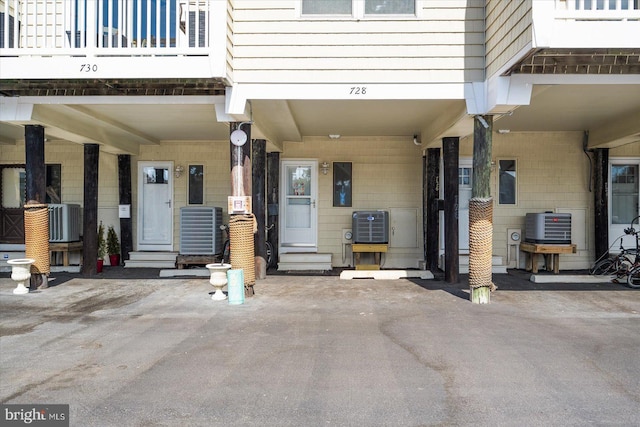 doorway to property featuring a balcony, ac unit, and central AC