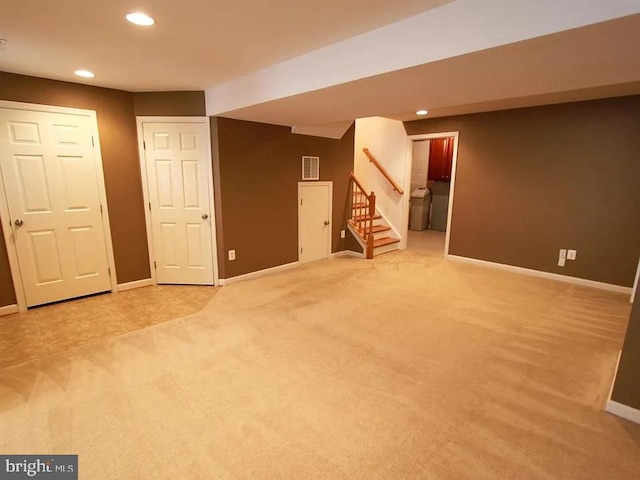 finished basement featuring recessed lighting, visible vents, baseboards, stairway, and carpet