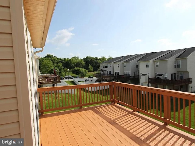 wooden terrace featuring a lawn and a residential view