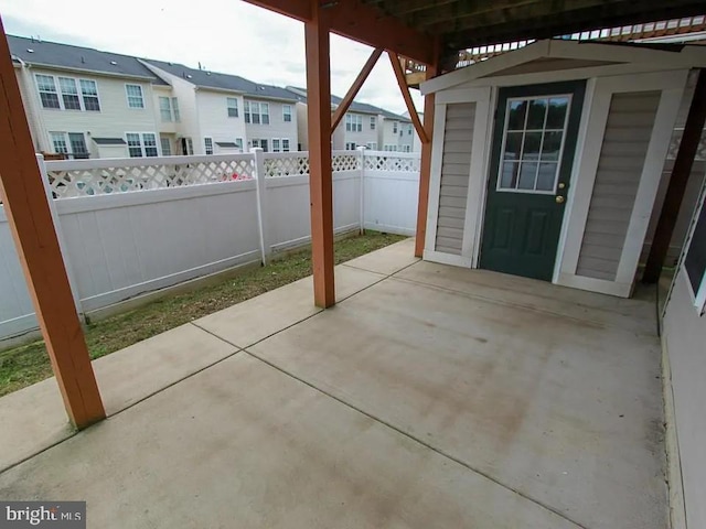 view of patio / terrace with an outbuilding, a shed, and a fenced backyard