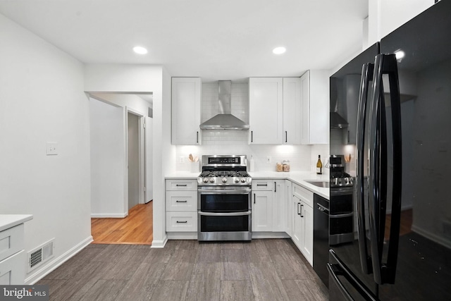 6910 Barnack Dr, Springfield, VA 22152 - kitchen with wall chimney exhaust hood, black appliances, dark wood-style flooring, light countertops, and decorative backsplash