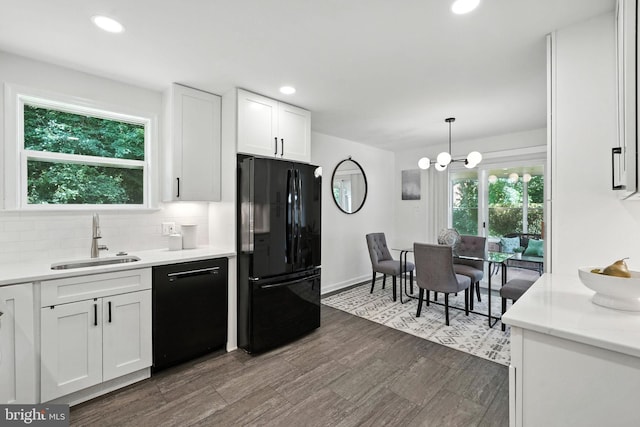 6910 Barnack Dr, Springfield, VA 22152 - kitchen with black appliances, white cabinets, tasteful backsplash, light countertops, and a chandelier