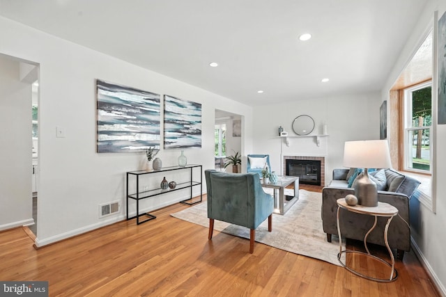 6910 Barnack Dr, Springfield, VA 22152 - living area featuring light wood-style flooring, a brick fireplace, healthy amount of natural light, and recessed lighting