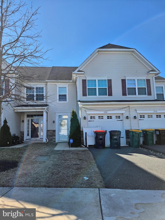 townhome / multi-family property with driveway and an attached garage