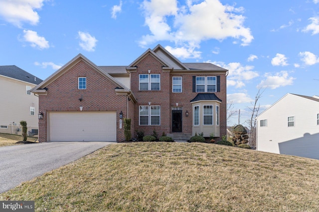 view of front facade with a garage, a front yard, aphalt driveway, and brick siding