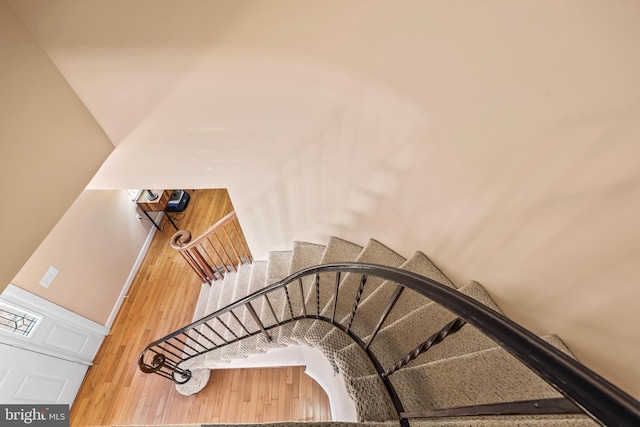 staircase featuring baseboards and wood finished floors