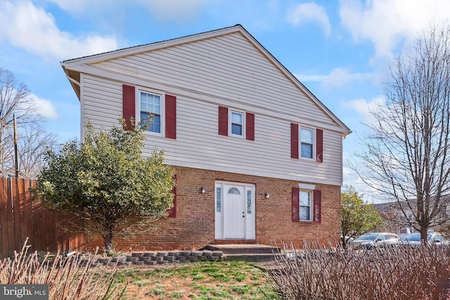 view of front of house with brick siding and fence