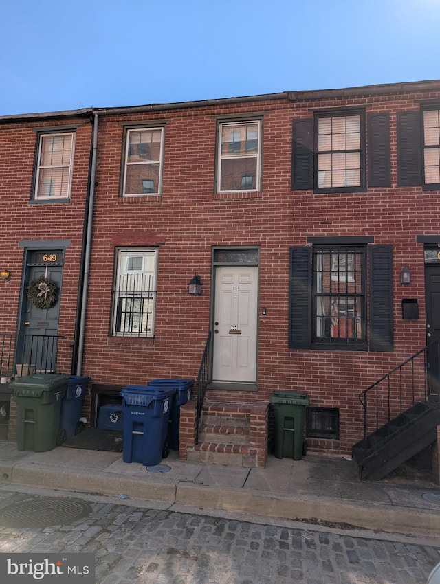 townhome / multi-family property featuring brick siding and entry steps