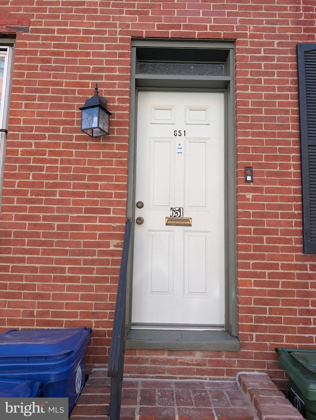 doorway to property with brick siding