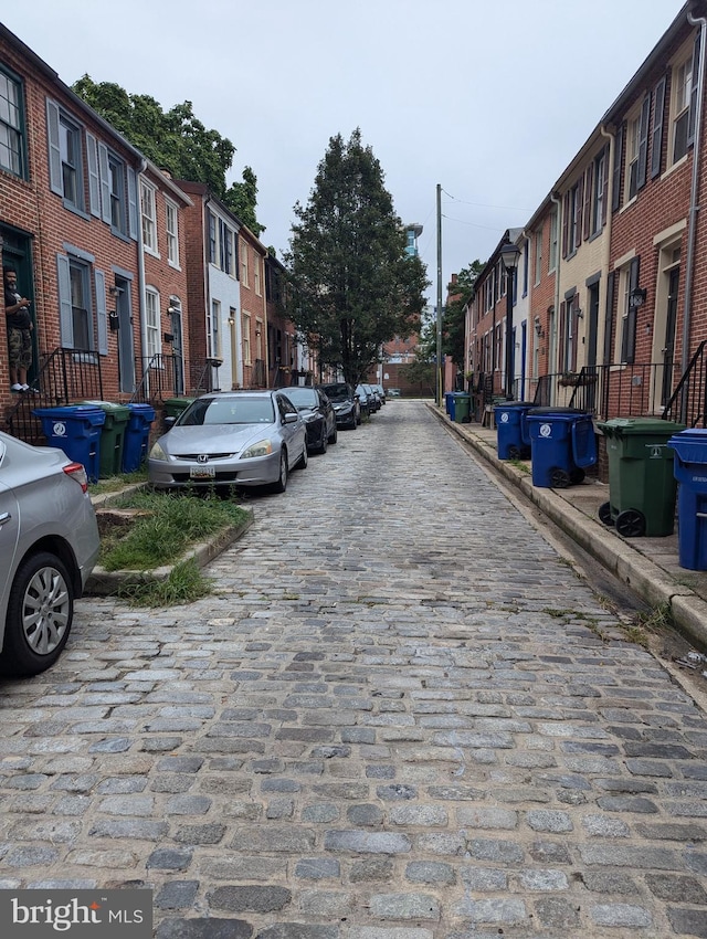 view of street with a residential view, curbs, and sidewalks