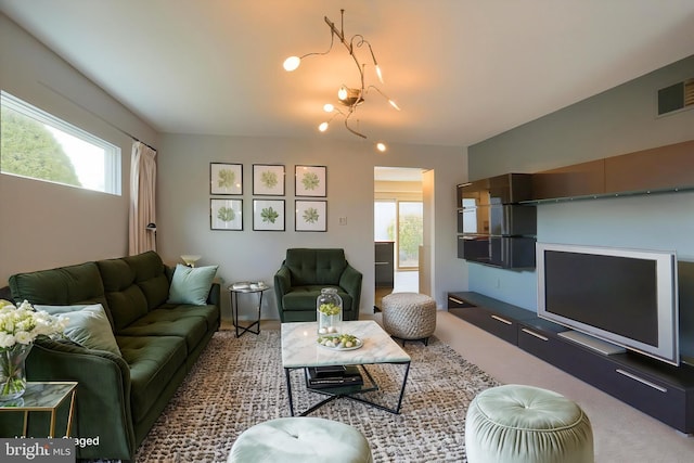 living area featuring a wealth of natural light, visible vents, and carpet