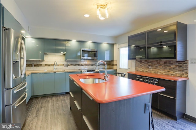 kitchen with stainless steel appliances, dark wood finished floors, a sink, and modern cabinets