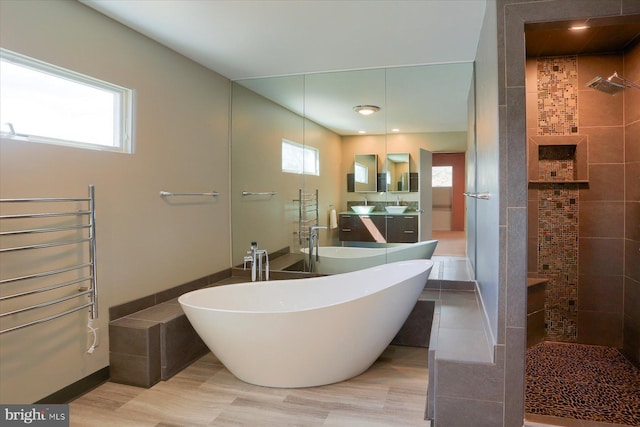 full bath featuring tiled shower, a wealth of natural light, and radiator