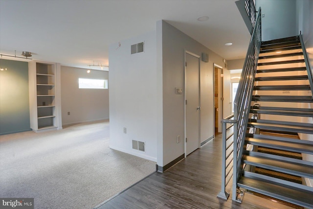 stairs featuring wood finished floors, visible vents, and baseboards