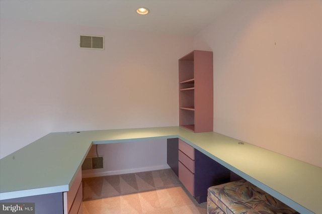 unfurnished office with recessed lighting, visible vents, built in desk, and light colored carpet