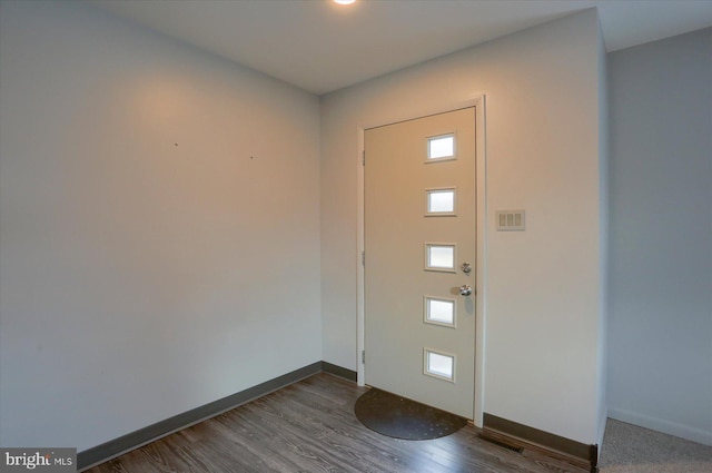 foyer entrance with dark wood-type flooring and baseboards