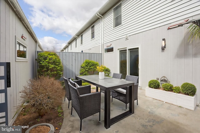 view of patio featuring outdoor dining area and fence