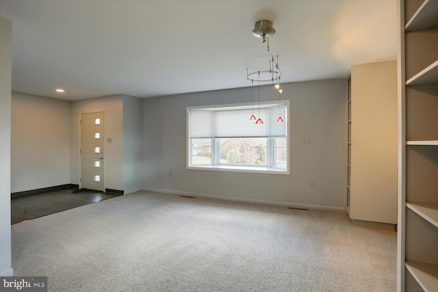 spare room featuring carpet floors, recessed lighting, visible vents, and baseboards