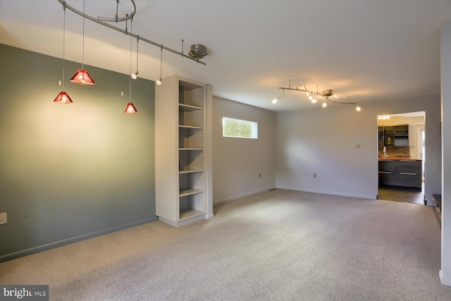 unfurnished living room featuring carpet floors and baseboards