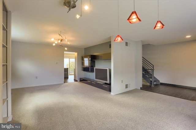 unfurnished living room with carpet floors, baseboards, stairs, and visible vents