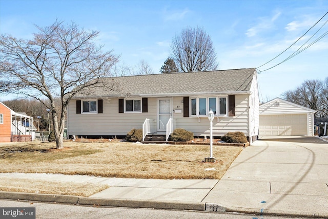 view of front of home with a shingled roof, an outbuilding, and a detached garage