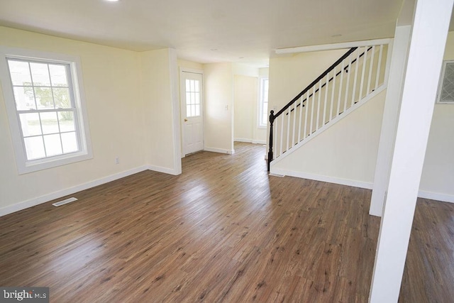 foyer featuring stairway, baseboards, visible vents, and dark wood-style flooring