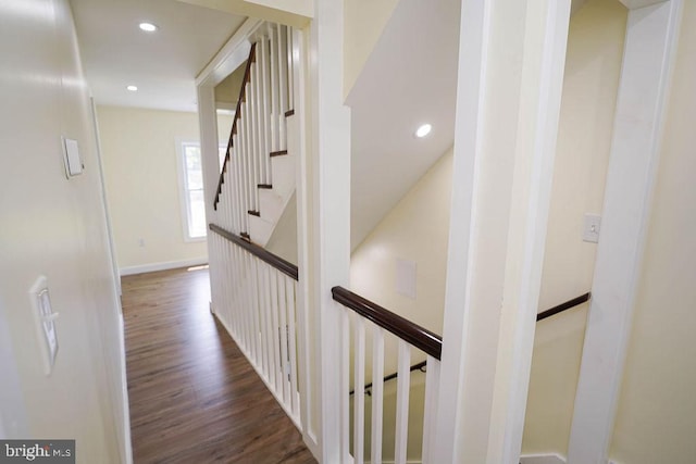 corridor with dark wood-style floors, recessed lighting, baseboards, and an upstairs landing