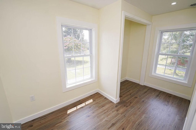 interior space featuring visible vents, baseboards, a wealth of natural light, and wood finished floors