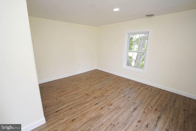 unfurnished room featuring light wood finished floors, baseboards, and recessed lighting