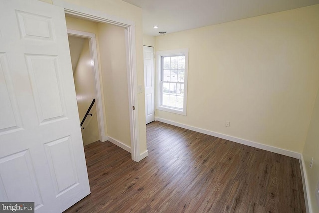 spare room with dark wood finished floors and baseboards