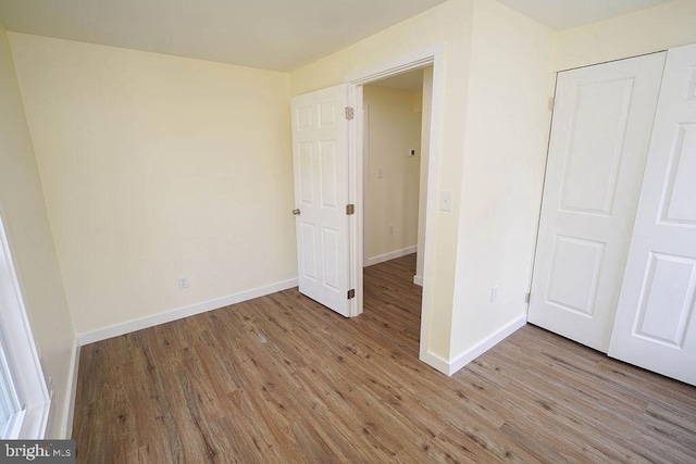 unfurnished bedroom with light wood finished floors and baseboards