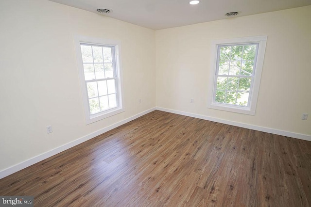 spare room with a healthy amount of sunlight, visible vents, and baseboards