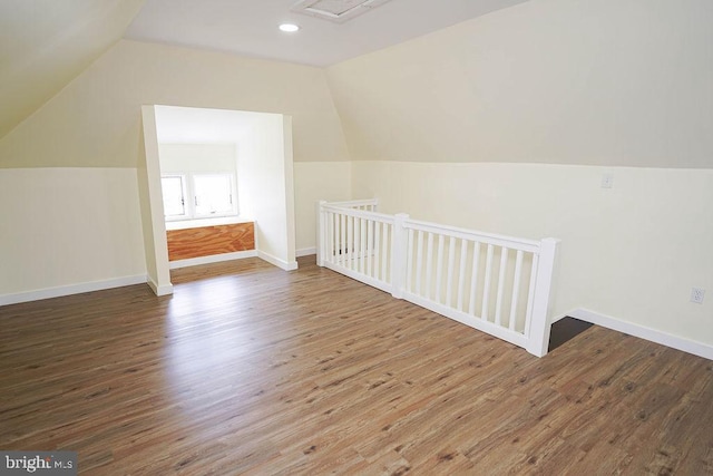 additional living space featuring lofted ceiling, wood finished floors, and baseboards