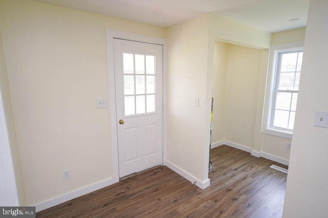 doorway with visible vents, baseboards, and dark wood-style flooring