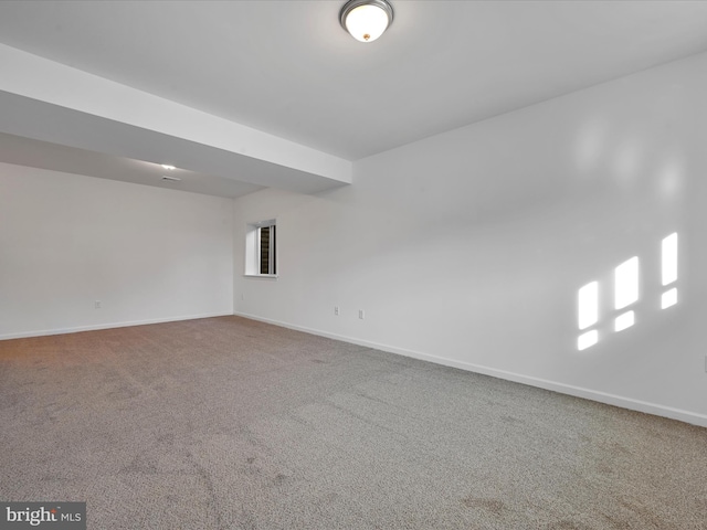 spare room featuring carpet and baseboards