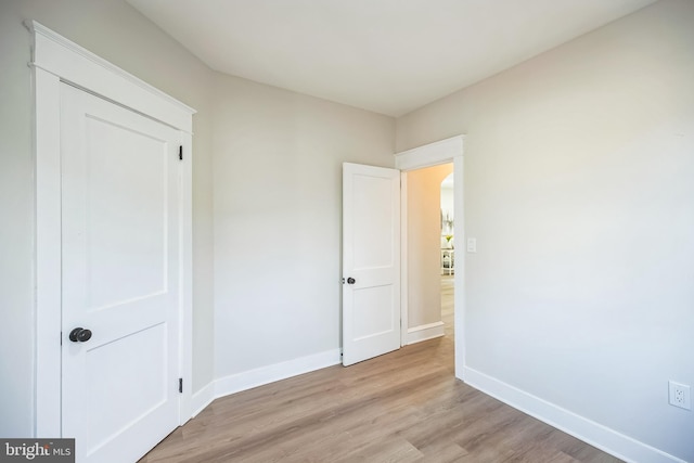 unfurnished bedroom featuring light wood finished floors and baseboards