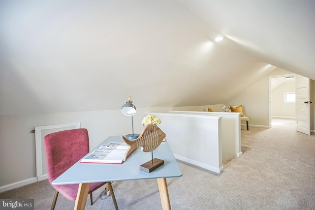 home office featuring light carpet, lofted ceiling, and baseboards