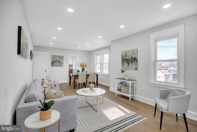 living room featuring light wood-style flooring, baseboards, and recessed lighting