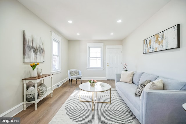 living area featuring recessed lighting, wood finished floors, and baseboards