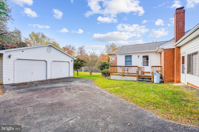 view of yard with an outbuilding, a detached garage, and a deck