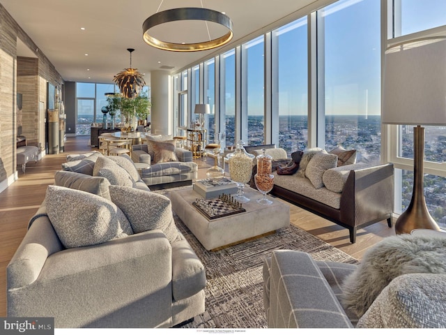 living room with a wall of windows and wood finished floors