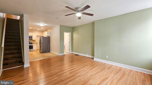 unfurnished living room with a ceiling fan, baseboards, stairway, and light wood finished floors