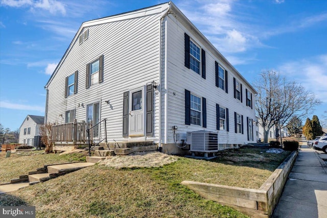 view of front facade featuring central air condition unit, a front yard, and entry steps