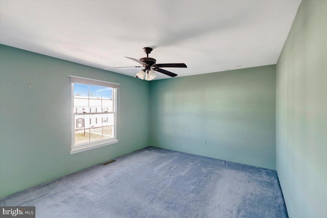 spare room with visible vents, a ceiling fan, and carpet floors