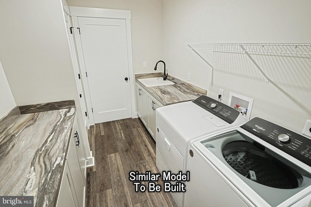 washroom with dark wood-style floors, cabinet space, a sink, and washing machine and clothes dryer