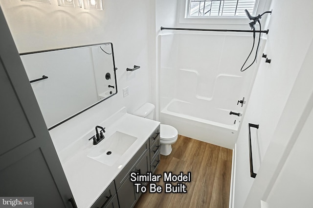 bathroom featuring wood finished floors, bathing tub / shower combination, vanity, and toilet