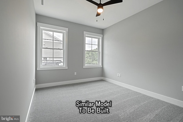 carpeted spare room with ceiling fan and baseboards